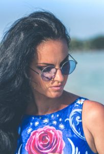 woman with blue top and blue glasses