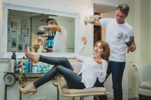 https://www.pexels.com/photo/woman-sitting-on-the-salon-chair-while-holding-vodka-glass-and-man-at-her-back-white-spraying-her-hair-696287/